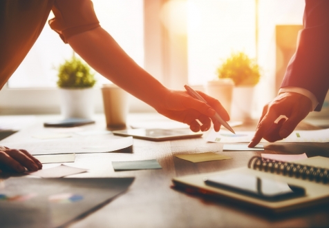 Hands pointing and signing a document.